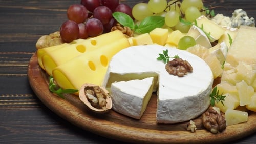 Assorted Cheeses, Grapes, and Nuts on Wooden Plate