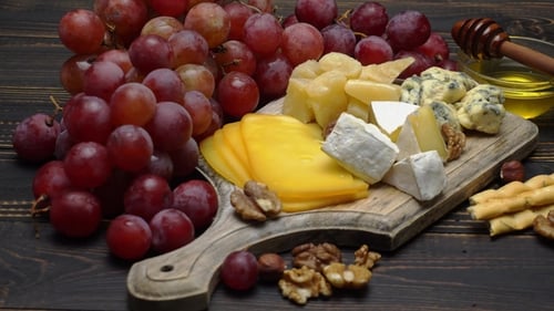 Cheese Board with Grapes and Honey Close Up
