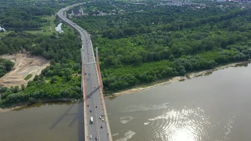 Car traffic on hanging sea bridge over bay in city view from above. Aerial View