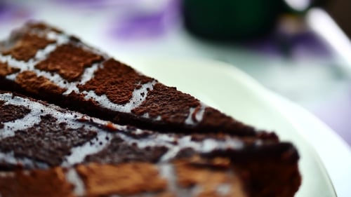 Leckerer Schokoladenkuchen in Scheiben auf Tischhintergrund