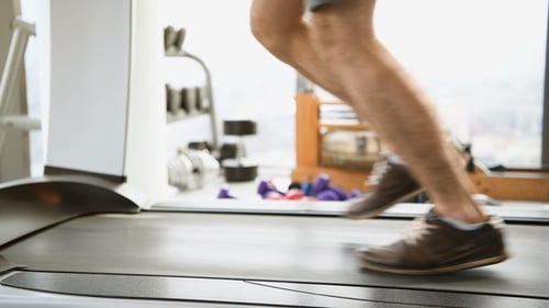 Sport, Fitness, Technology and People Concept - of Male Legs Running on Treadmill in Gym