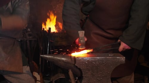 Two Blacksmiths Work With Hammer and Anvil