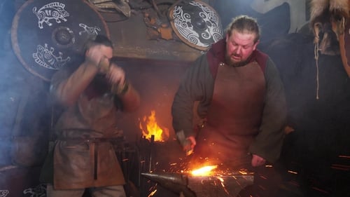 Two Blacksmiths Forging Metal with Fire and Hammers