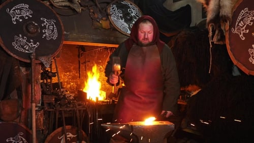 Blacksmith Forging Metal in Dark Workshop