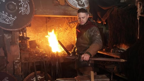 Swordsmith Forging Steel Sword in Dark Workshop