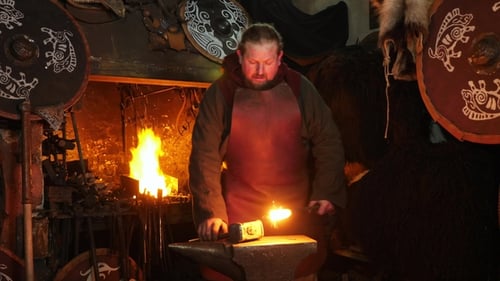 Blacksmith Forging Metal in Dark Workshop