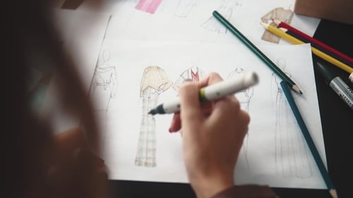 Designer of Clothes Makes an Outline of Clothes with a Felt-tip Pen. Female Hands