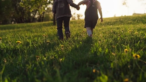 Children Holding Hands and Walking Together on Grass, Sunny Summer Day