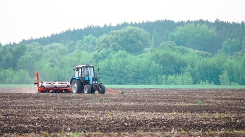 Tractor Works Plows the Field Before Planting the Harvest
