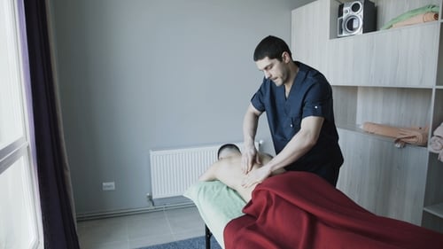 Massage Therapist Giving a Back Massage to Client