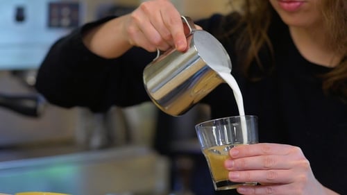 Barista Pour Hot Milk Into a Coffee