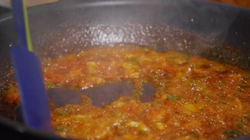 Tomato sauce cooking in a pan with spatula