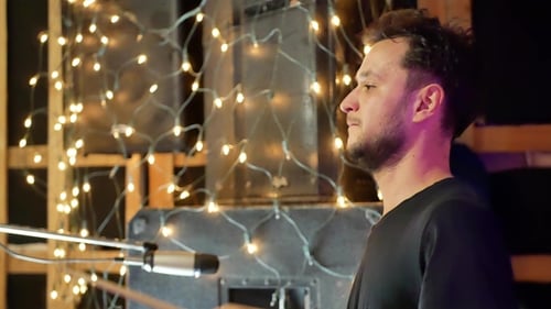 Male Drummer Practices in Warmly Lit Studio