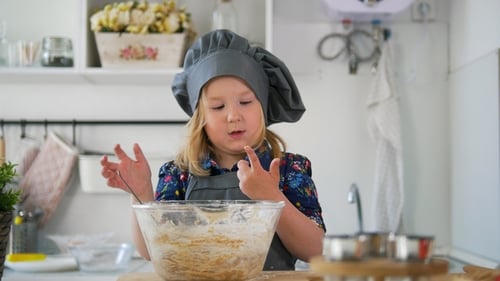 Preschool Girl Baker Mixes the Dough in a Bowl