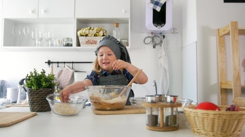Little Girl Adds Ingredients To the Pastry Dough