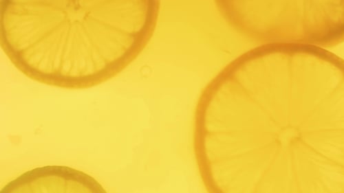 Lemon Slices Floating in Bright Yellow Liquid
