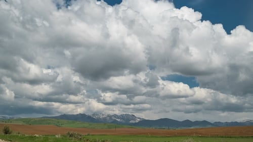 Fields and Storm Clouds Over Mountains