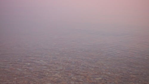 Gentle Waves on Pebble Beach at Sunset