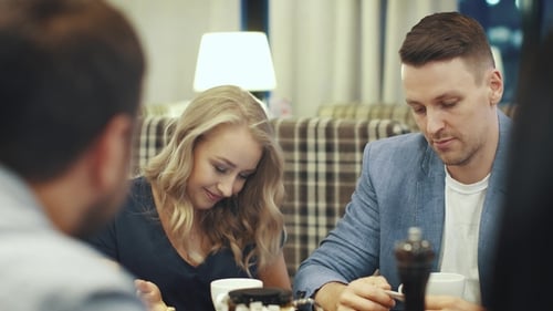 Friends Laugh and Have Fun Sitting at a Table in a Restaurant