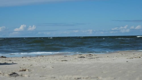 Sandy Beach with Waves of the Blue Sea under Blue Sky