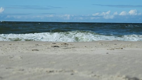Sandy Beach with Waves of the Blue Sea under Blue Sky