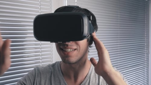 Young Man Using His VR Headset for Watching the 360 Video at Office Background
