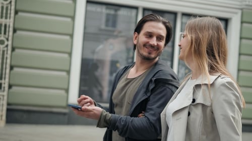 Couple of Tourists Walking in a City Street with Phone Use Navigation Applications, Man and Woman