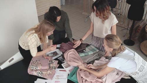 Fashion Designers Choose Fabrics for a New Collection of Clothes. a Group of Designers Works in a