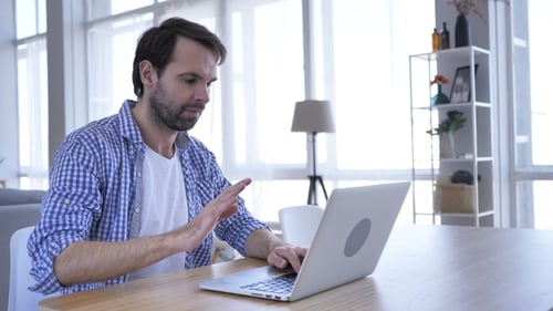 Man Typing on Laptop Computer at Home