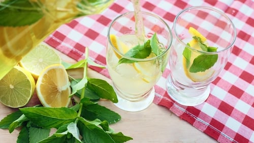 Pouring Refreshing Lemonade with Ice and Mint