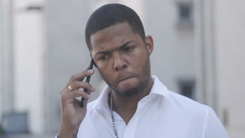 Serious Man Talking on Smartphone in City Setting