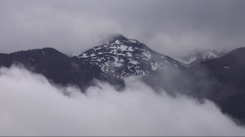 Sommet de la montagne dans la neige et les nuages dans les Alpes