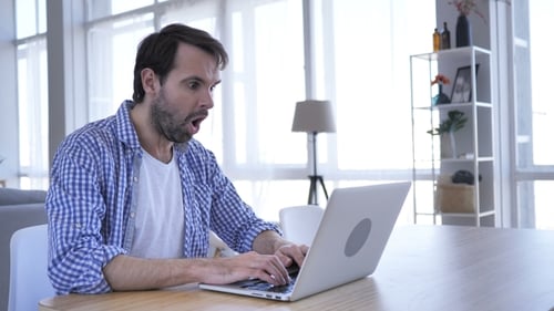 Casual Beard Man in Shock Working on Laptop