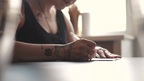 Tattoo Artist Makes a Sketch of Tattoo on Paper in a Home Studio