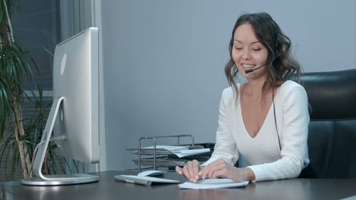 Young Asian Operator Talking with Customer in International Call Center