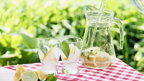 Refreshing Lemonade Being Poured into Glass Pitcher