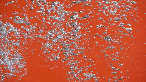 Air Bubbles in the Pouring Water Splash on Orange Background