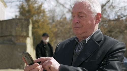 Wrinkled Man Seeks Info on His Mobile in an Alley in Spring in