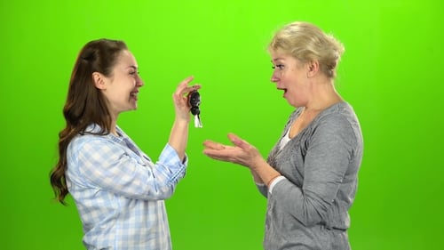 La fille donne les clés à sa mère. Écran vert