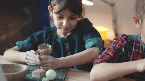 Girl Sculpting Clay at Pottery Studio with Friend