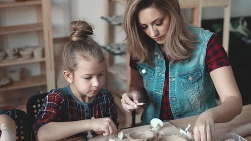 Woman and Child Making Clay Figures Together