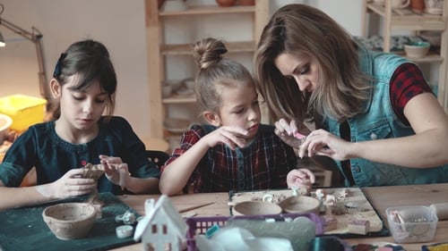 Woman and Children Sculpting Clay Indoors