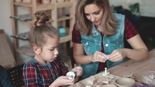Woman and Child Working With Clay Together