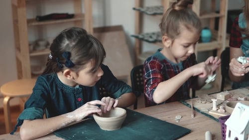 Children Making Pottery Together With Adult Supervision