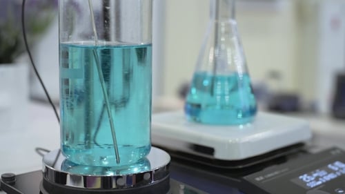 Blue Liquid Mixing in Lab Beakers