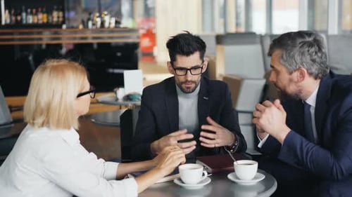 Corporate Managers Mature Businesspeople Talking in Cafe Discussing Work