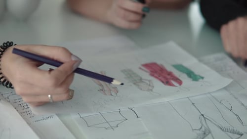 Designer of Clothes Makes an Outline of Clothes with a Felt-tip Pen. Female Hands