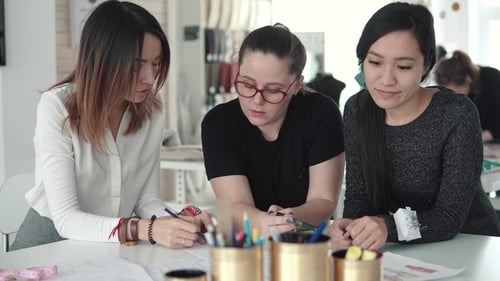 Gruppe von Geschäftsfrauen, die an einem Startup eines kleinen Ateliers arbeiten. Mehrere Modedesigner diskutieren