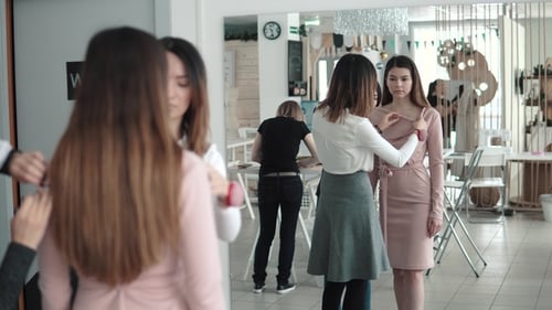 Lively Work in a Small Atelier. Fashion Designer and Her Assistant Trying on a Model