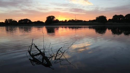 Wunderschöner Sonnenuntergang am Ufer des Sees. Sommerurlaub.